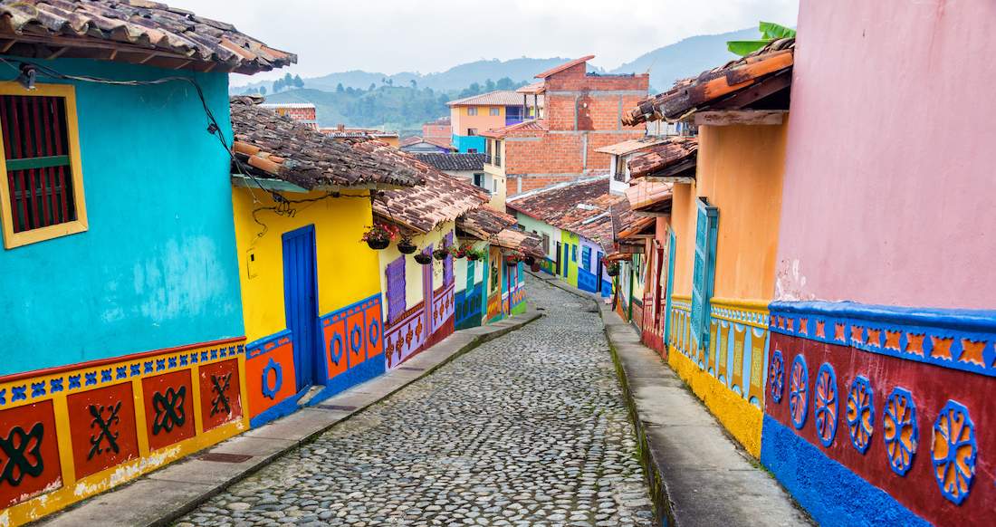 Bogota Colombia Colourful buildings line a cobblestone road with mountains in the background