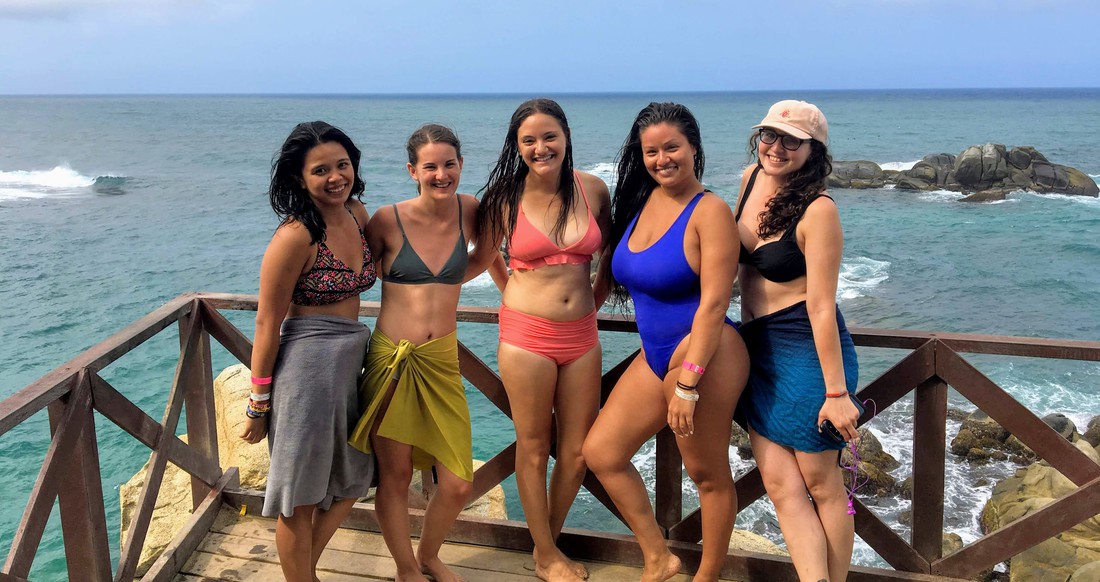 Beach Group Shot Girls A group of girls in bathing suits pose next to the Caribbean.