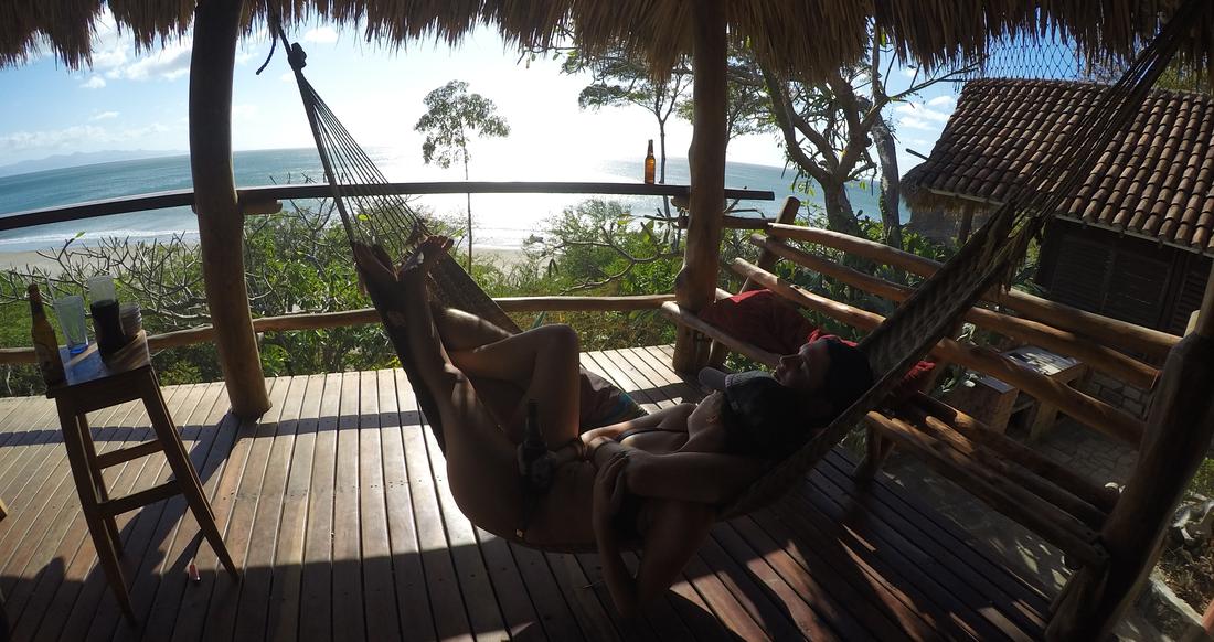 Hammock Nicaragua A couple lounges in a hammock that overlooks the ocean
