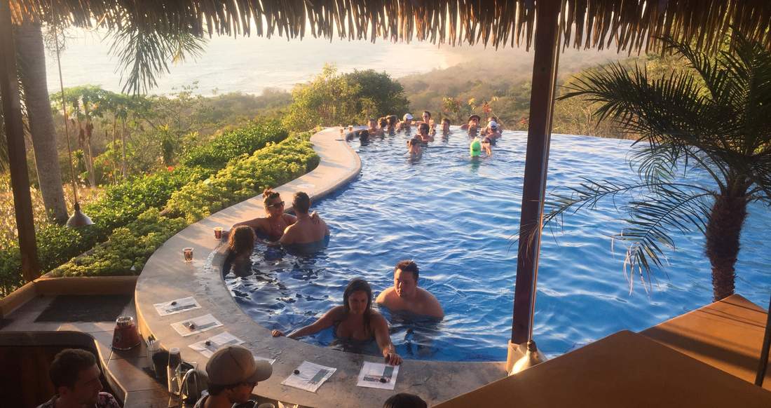 Pool Costa Rica People swim up to a bar in a pool surrounded by lush jungle with a view of the ocean