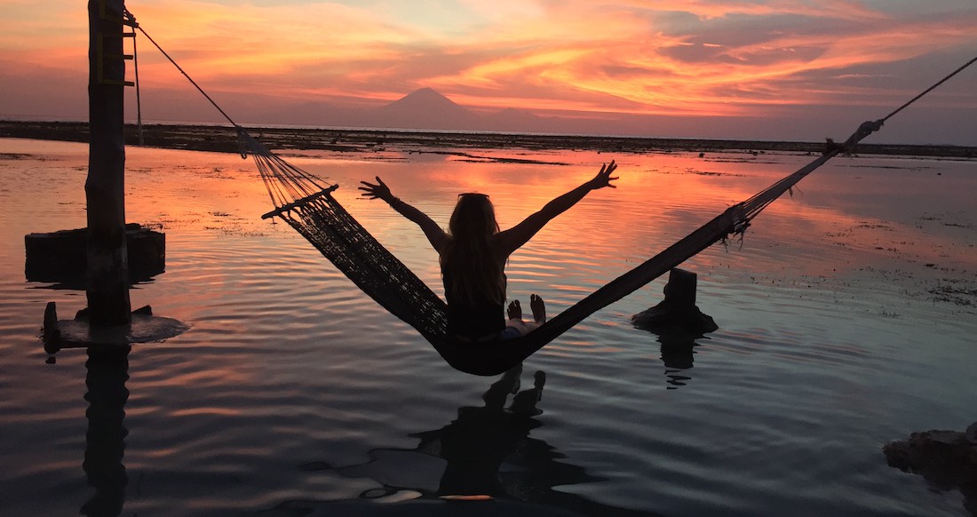 Sunset Hammock Indonesia Girl watching beautiful sunset from a hammock in Indonesia