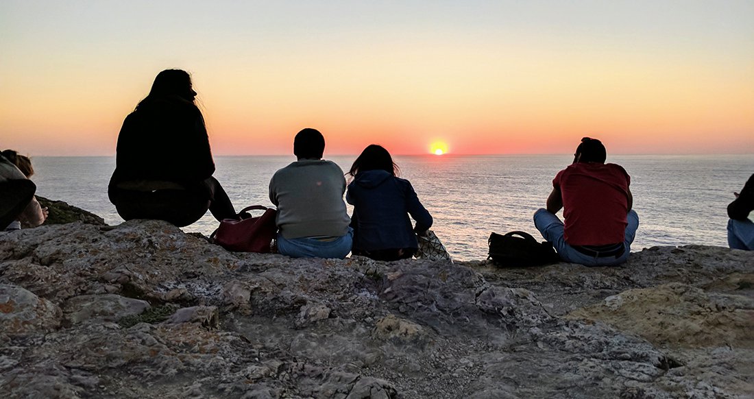 Sunset at Cabo de São Vicente A group of travelers watch the sunset over the ocean