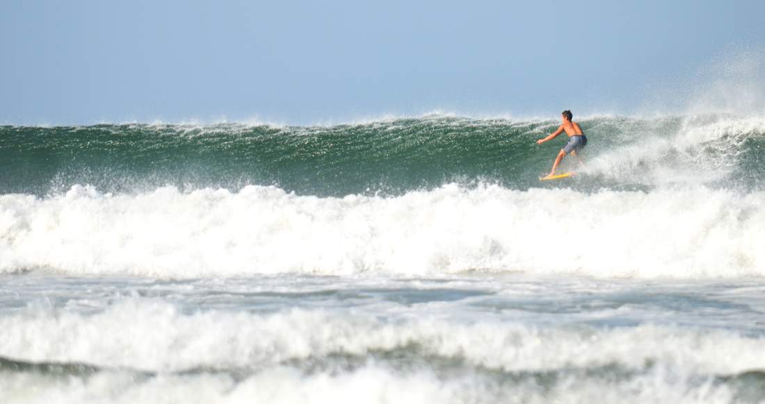 Surfing Costa Rica A man on a surfboard rides a large wave