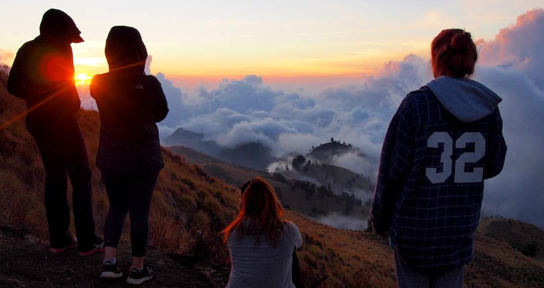 Volcano Hike Group of people in warm clothing watching the sunrise over a volcanic crater