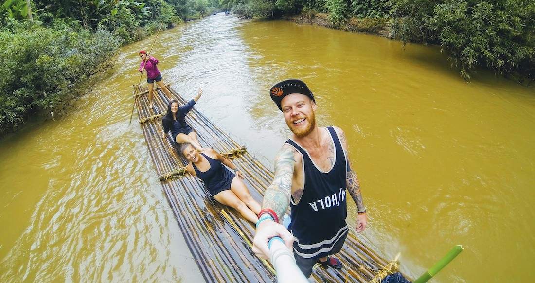 bamboo rafting Group of travelers floating down a river on a bamboo raft in Northern Thailand