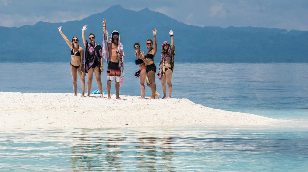 white sand beach A group of travelers smiling on a white sand beach in the Philippines