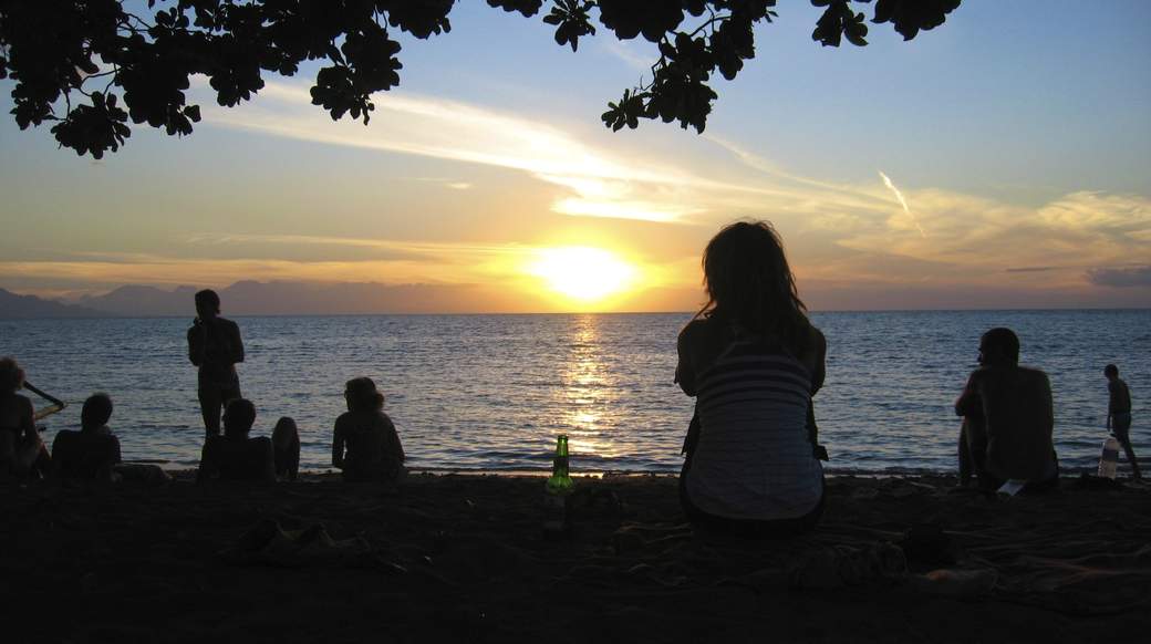 Beach sunset Travelers enjoying beer while watching the sun set on a beach in Indonesia