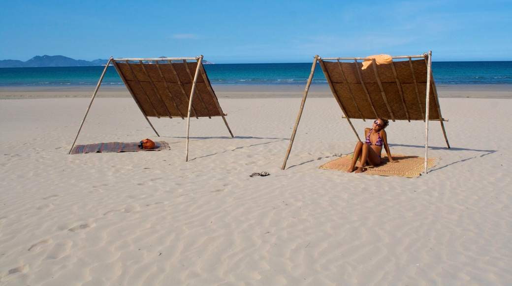 Sunny beach day Girl looking for shade on a beach in Vietnam