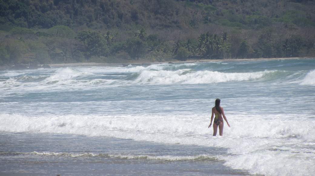 big waves girl standing in the ocean with big waves in Costa Rica