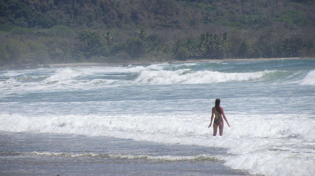 big waves girl standing in the ocean with big waves in Costa Rica