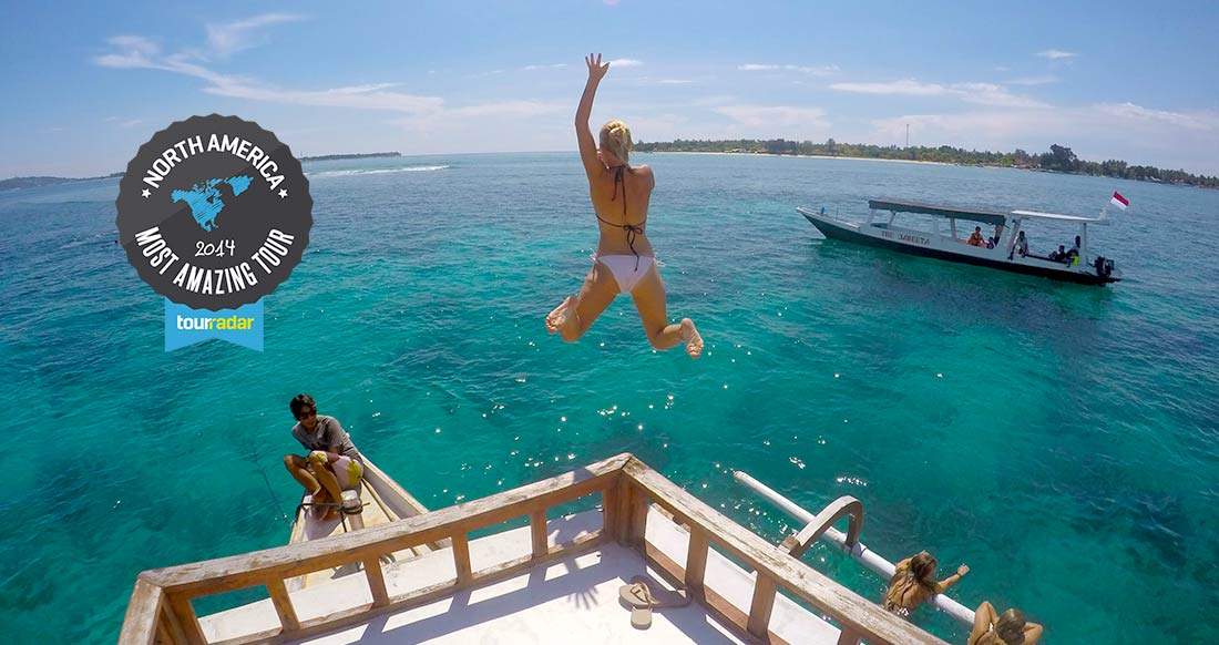 Boat trip Costa Rica and Panama Girl jumps from boat into turquoise waters as a boat watches nearby