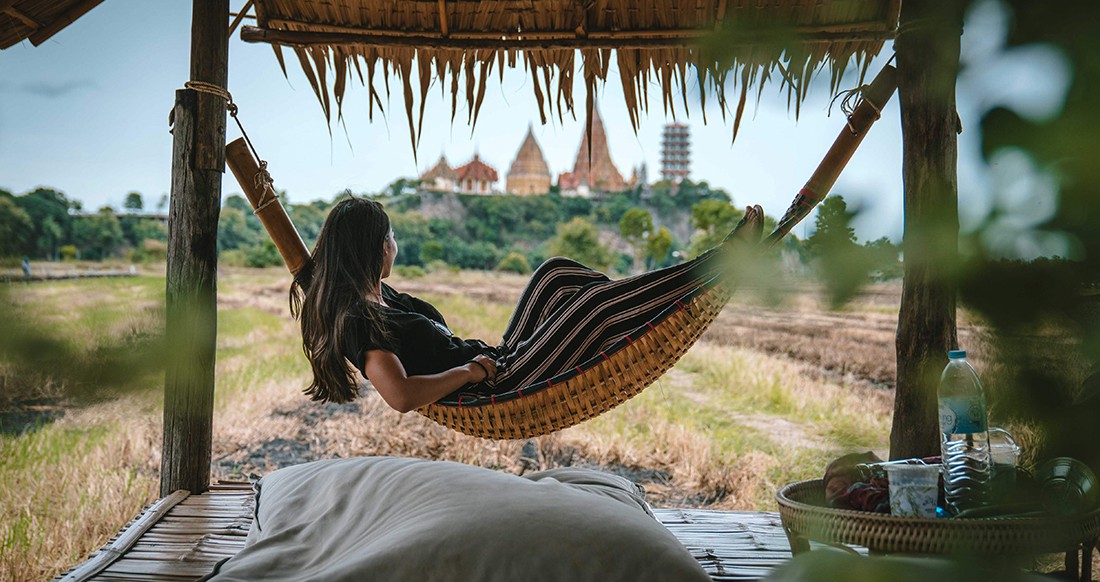 Girl in a hammock in Thailand Girl in a hammock with a view of a temple in Thailand