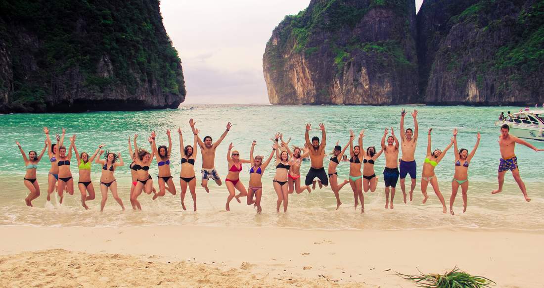 Maya Bay Group of travelers jumping up on Maya Bay beach in southern Thailand