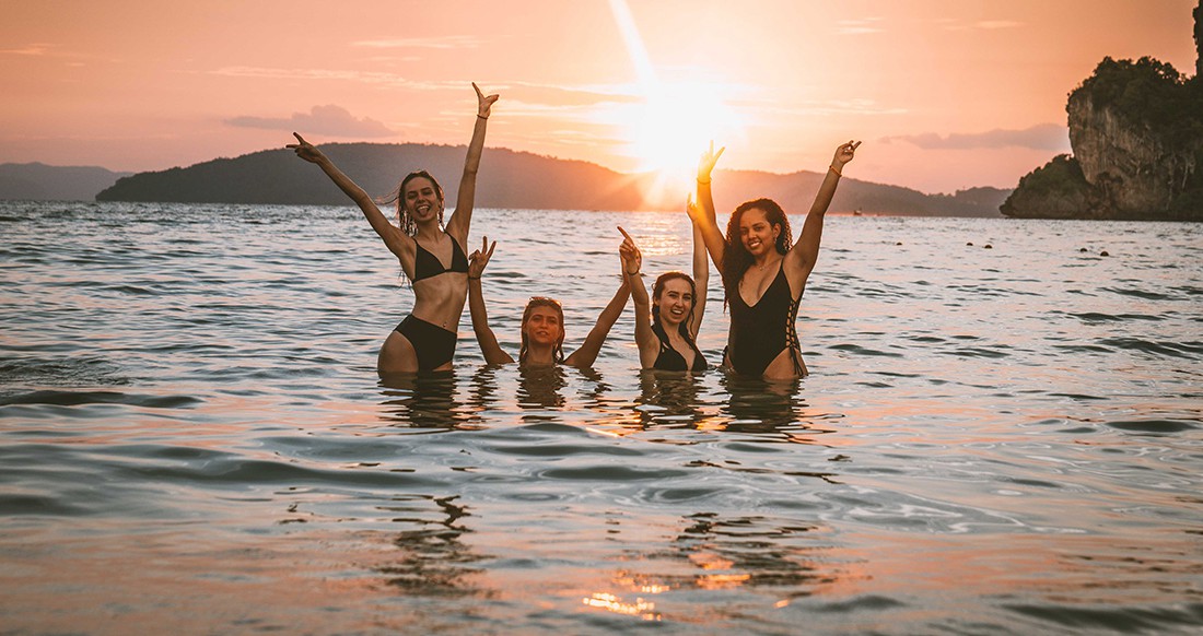 Railay beach Thailand sunset Girls in the ocean while the sun is setting at Railay beach Thailand