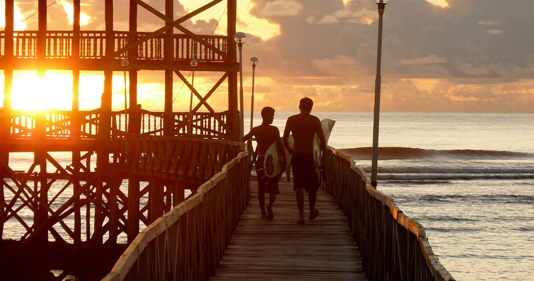 Sunset in Siargao Philippines Two travelers walking along a boardwalk while the sun sets in the Philippines
