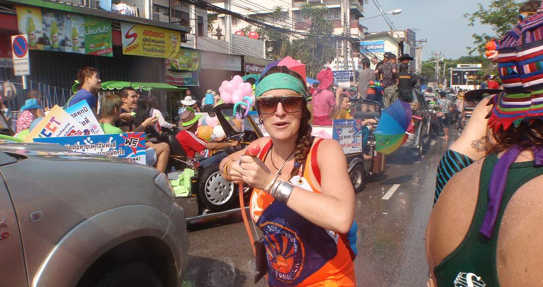 Water gun traveler participating in Songkran by splashing people with water
