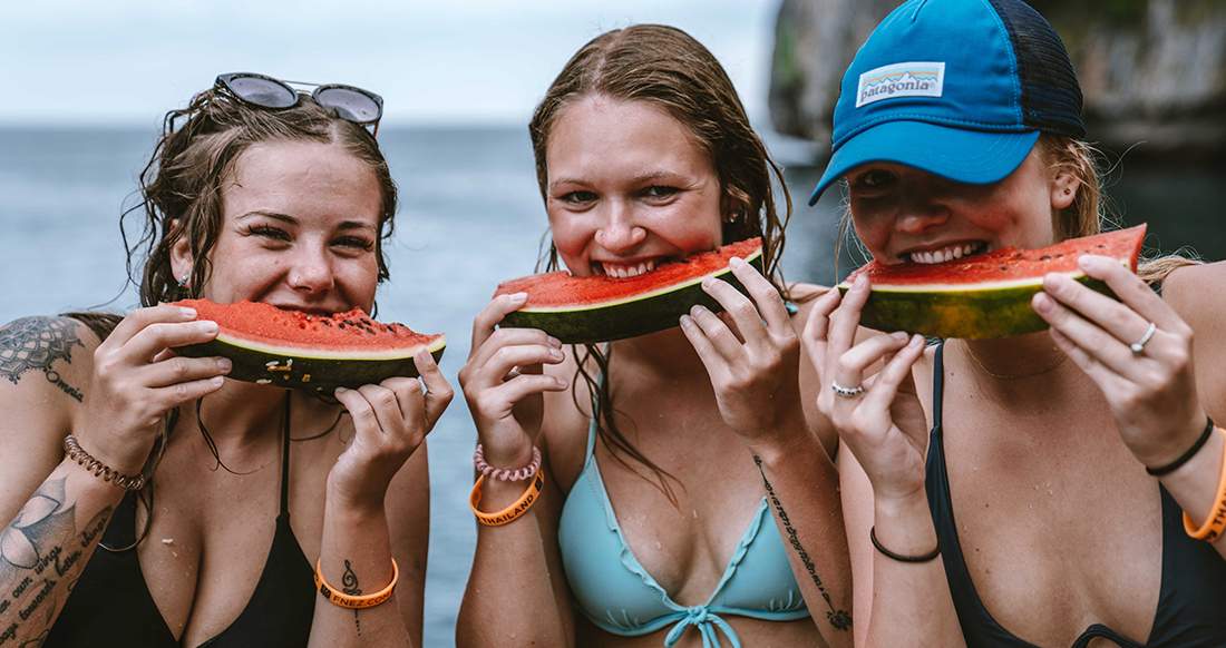 watermelon smiles three girls holding watermelon up to their smiles in southern Thailand