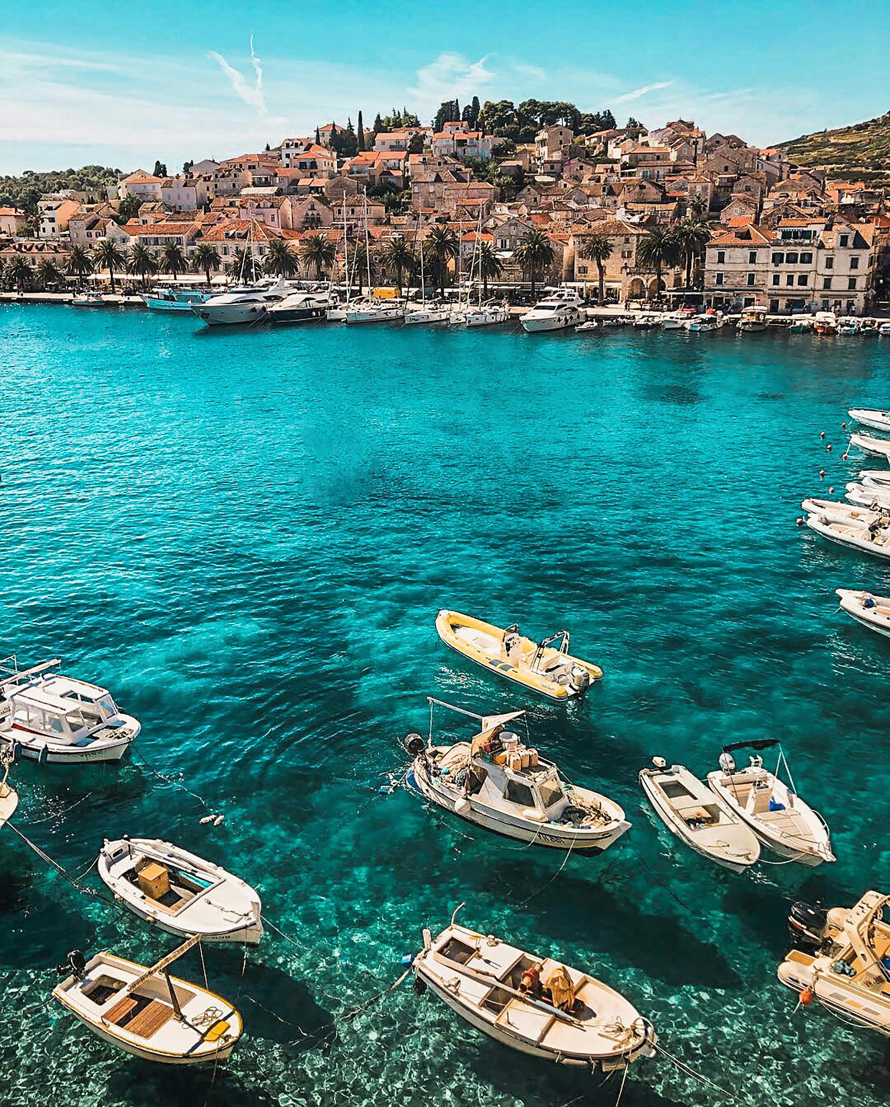 Turquoise harbour of Hvar, Croatia, with boats and the old town on the hillside